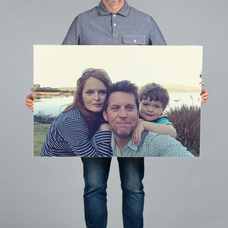 A man holding a 90x60cm canvas print featuring a family selfie in west cork