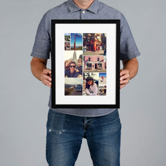 A man holds a bespoke framed collage print against a plain gray studio background. The print has a black frame, white mat, and multiple travel and portrait photos arranged in a custom collage design. 
